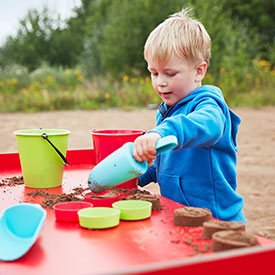 Boy playing with sand in a playground 